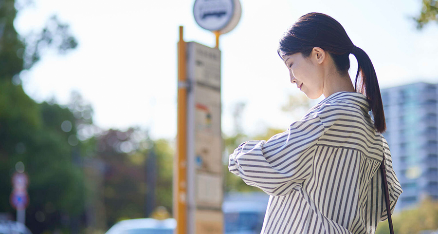 バス停でバスを待つ女性のイメージ画像