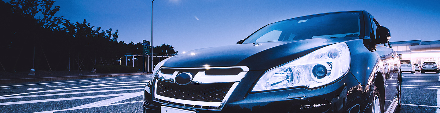 薄暮の中停車している自動車を撮影したイメージ画像