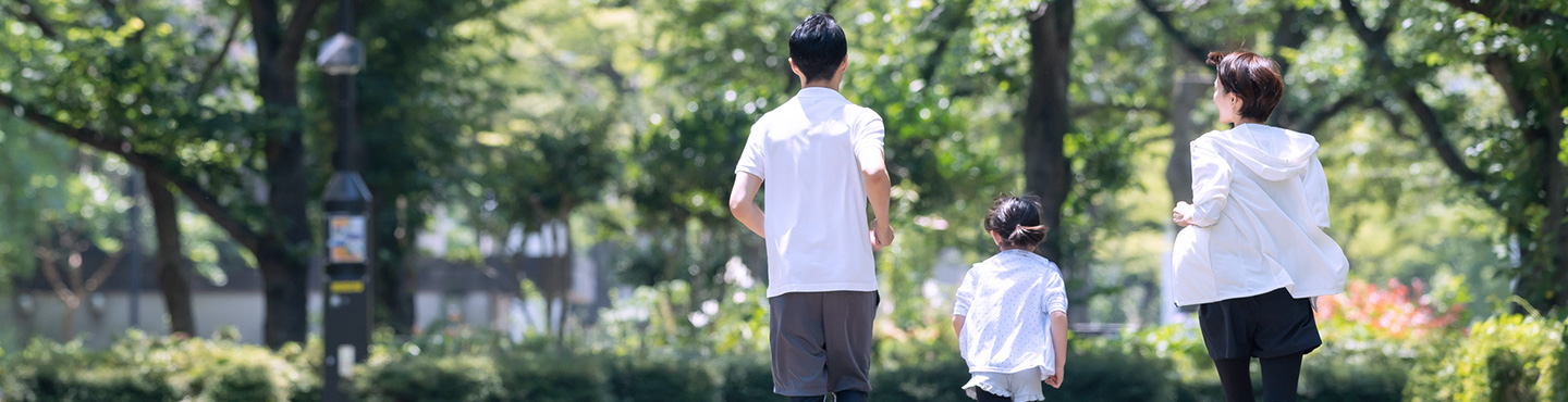 親子が緑豊かな道をランニングをしているイメージ画像