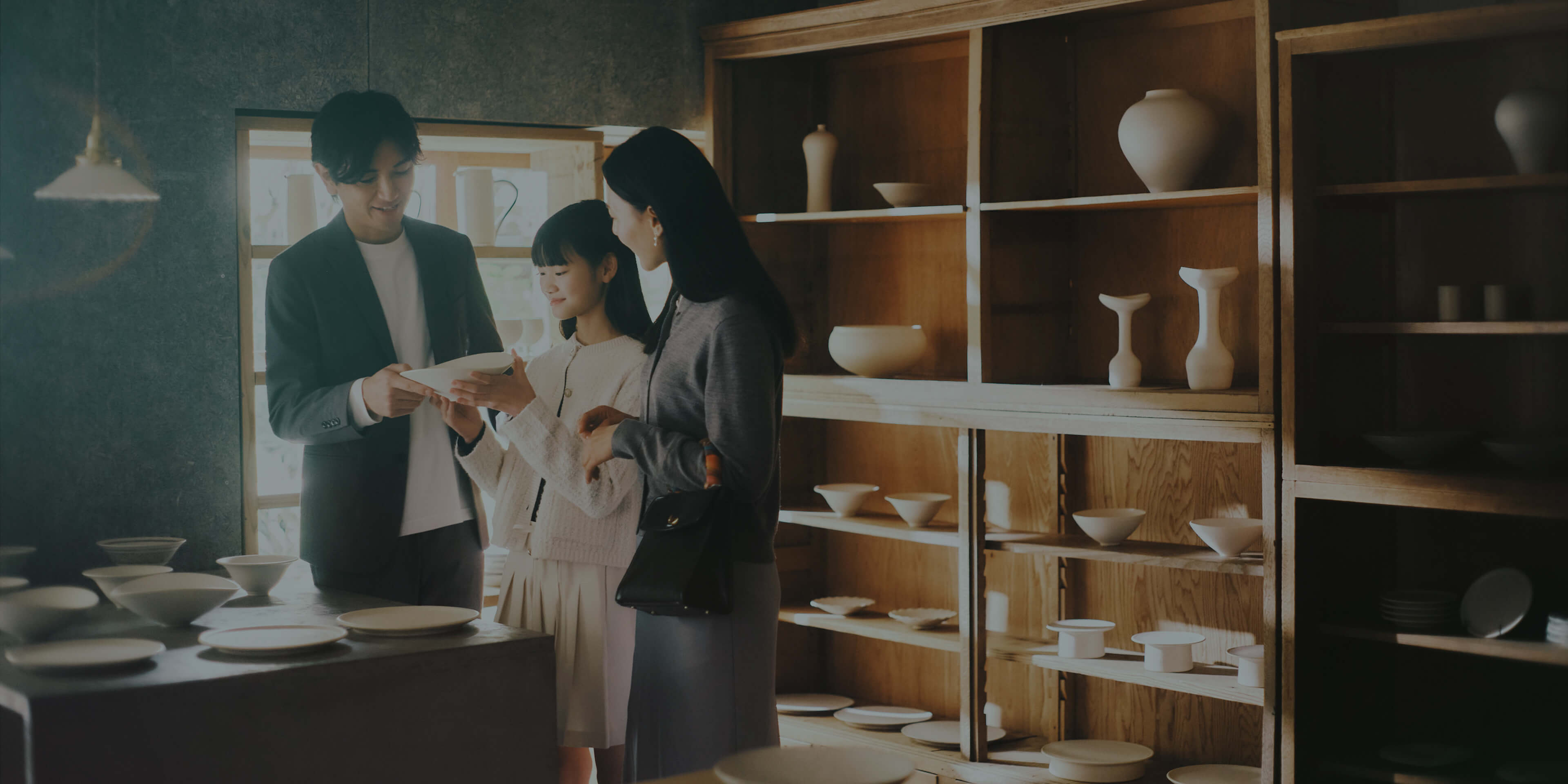 うつわ base FUURO で工芸品を手に取る家族