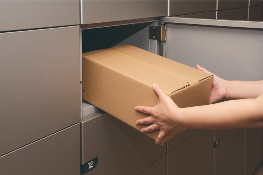 宅配ロッカーに荷物を入れているイメージフォト