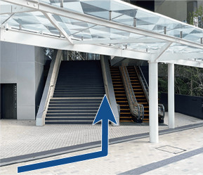 オフィスエントランスの、上り階段とエスカレーターの手前