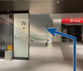 手前にエスカレーター、奥に郵便局があります。