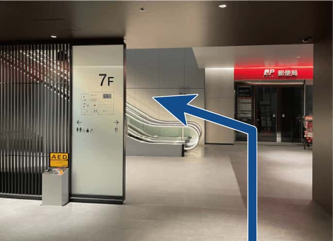 手前にエスカレーター、奥に郵便局があります。